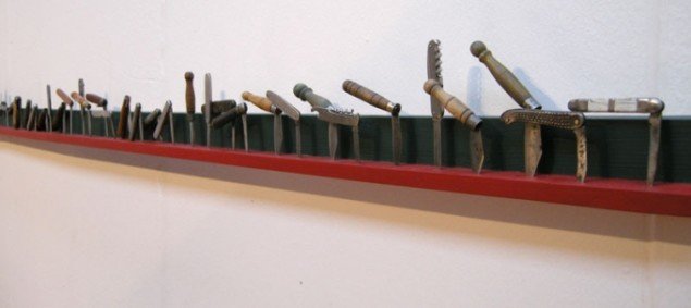 Det 3 meter lange værk "Prairie Design" af ungarske Károly Elekes. Lommeknivene er placeret i forhold til noderne i Bartók Bélas folkevise fra 1905 " My baby is ploughing ". 2B Gallery, Ungarn
