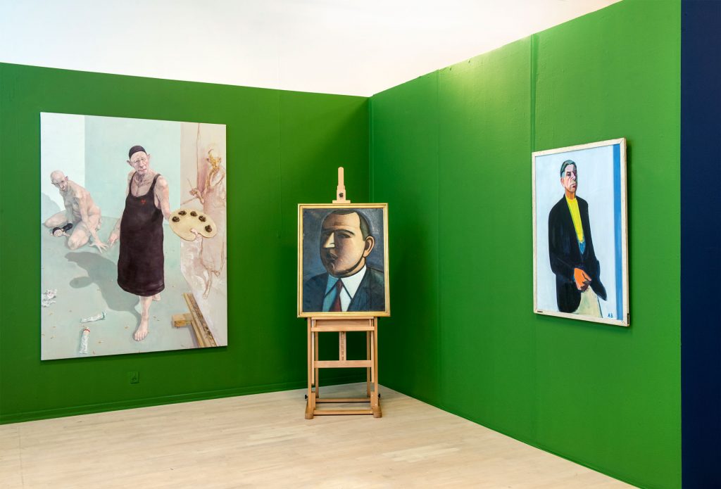 Installationsfoto med Michael Kviums Fools (1993-2014) i forgrunden og portrætter af Harald Giersing, Svend Wiig Hansen og en lang række andre kunstneren i baggrunden.